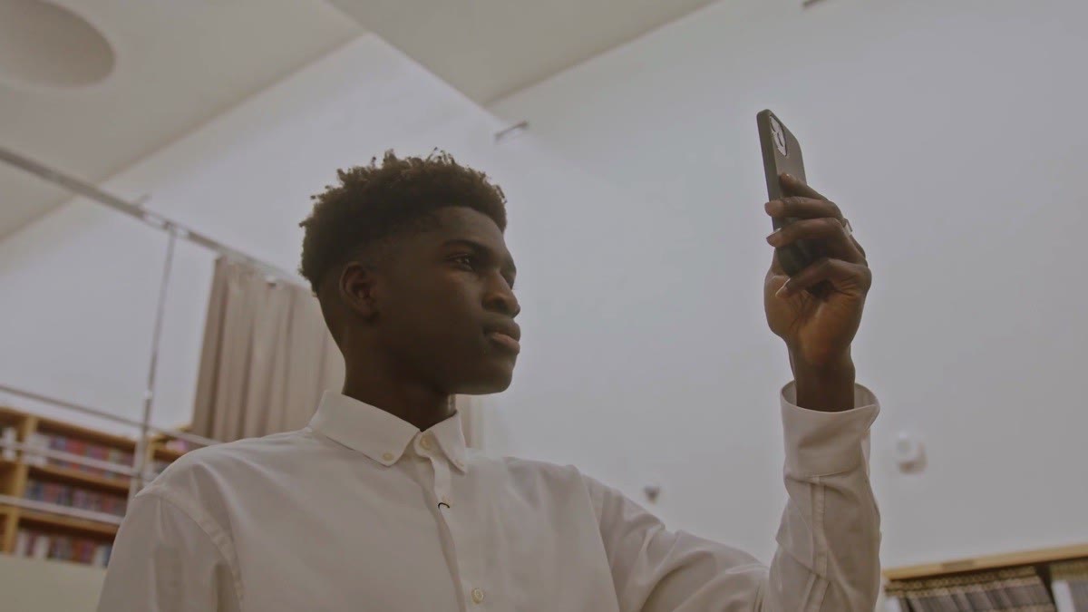 Joven usando la cámara de su celular para reconocer un elemento del lugar